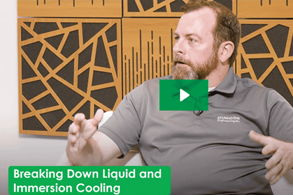 man gesturing in video still about liquid and immersion cooling